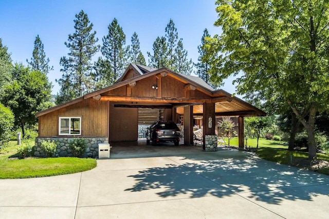 view of front of property with a front yard, stone siding, and driveway