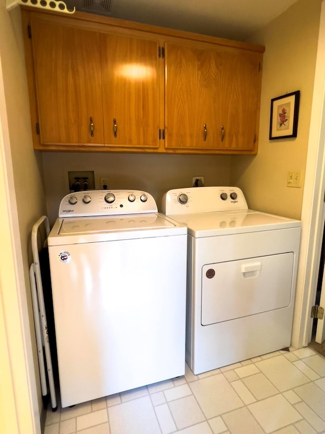 washroom with independent washer and dryer and cabinet space