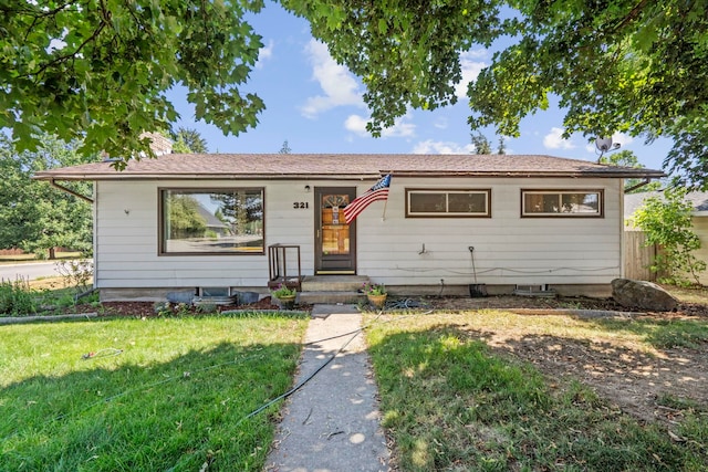 single story home with a chimney and a front lawn