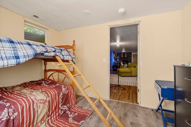 bedroom featuring visible vents and wood finished floors