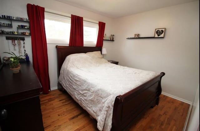 bedroom with wood finished floors and baseboards