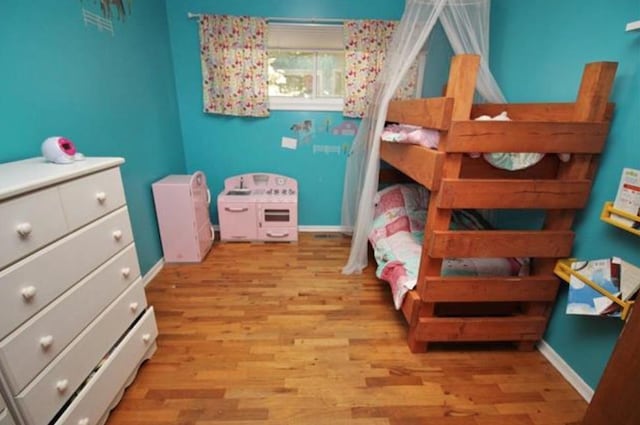 bedroom with baseboards and wood finished floors