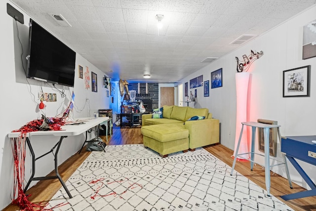 living area featuring visible vents and wood finished floors