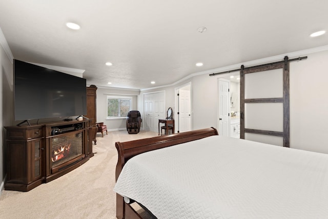 bedroom featuring a barn door, recessed lighting, light colored carpet, a lit fireplace, and ornamental molding