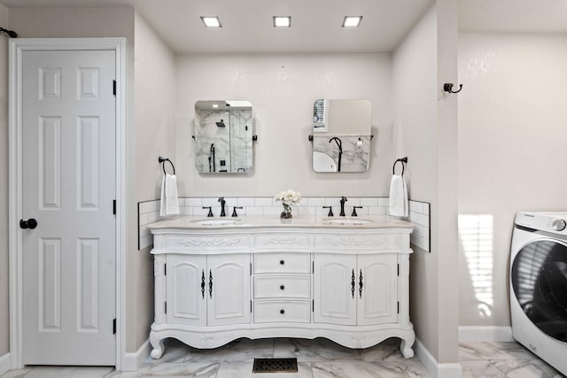 full bathroom with washer / dryer, marble finish floor, a shower, and a sink