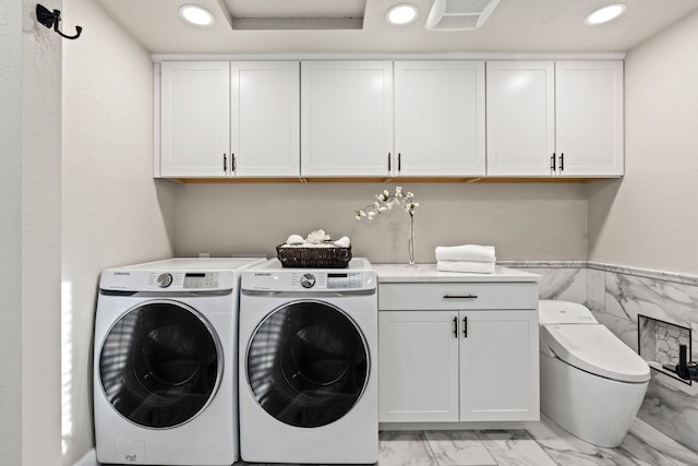 washroom featuring marble finish floor, washing machine and dryer, cabinet space, and recessed lighting