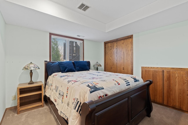 bedroom with light carpet, a closet, and visible vents