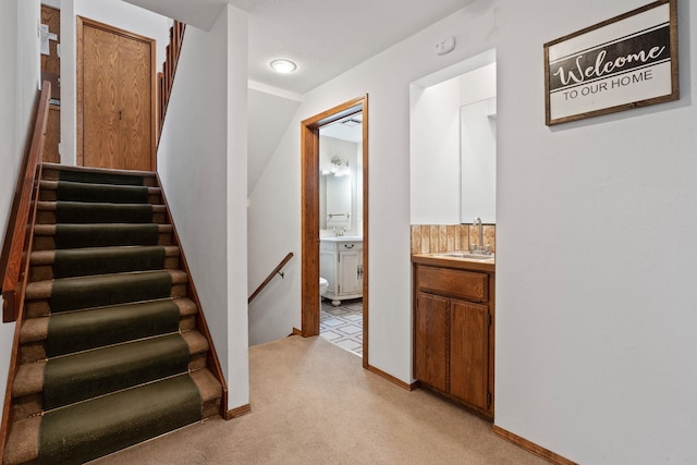 staircase featuring carpet floors and baseboards