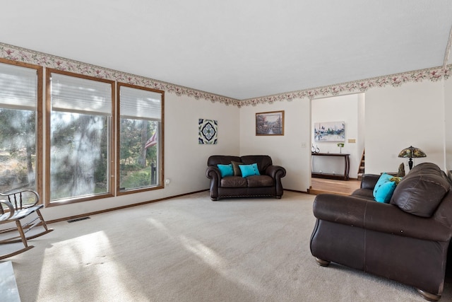 living room featuring stairway, carpet, visible vents, and baseboards