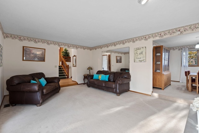 living room featuring light carpet, stairway, and baseboards