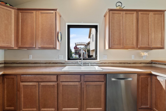 kitchen with light countertops, brown cabinets, a sink, and stainless steel dishwasher