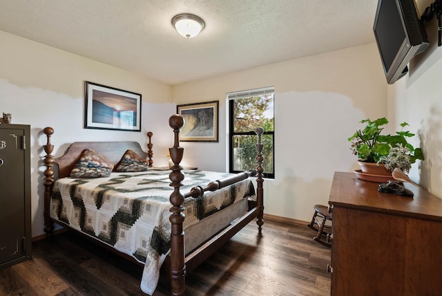 bedroom with a textured ceiling, dark wood finished floors, and baseboards