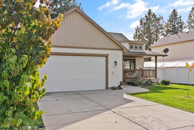 view of front of home with a garage, driveway, roof with shingles, and a front yard