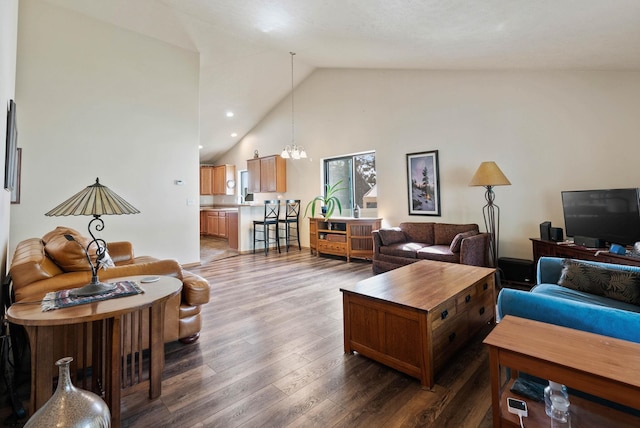 living room featuring high vaulted ceiling, recessed lighting, dark wood finished floors, and an inviting chandelier