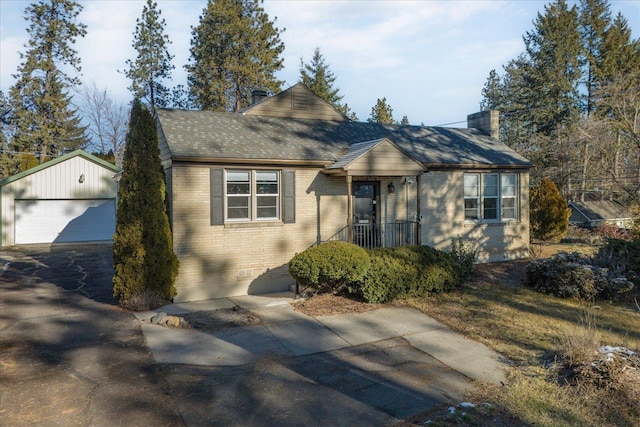 view of front of house with a garage, a chimney, roof with shingles, an outdoor structure, and brick siding