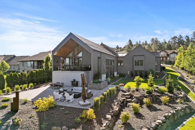 rear view of property featuring a patio area, a yard, and fence