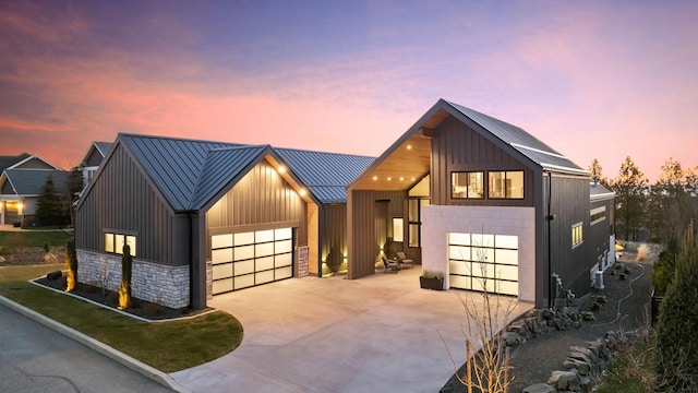 modern farmhouse featuring a standing seam roof, stone siding, metal roof, and board and batten siding