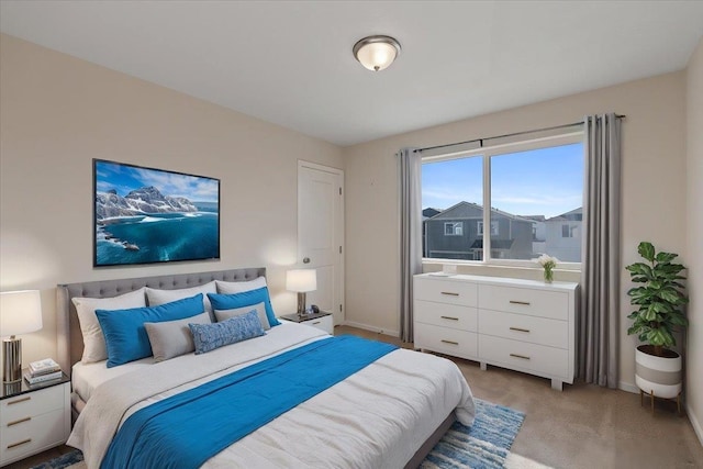 bedroom featuring light colored carpet and baseboards