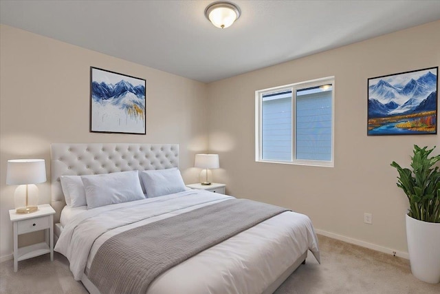 bedroom with light carpet and baseboards