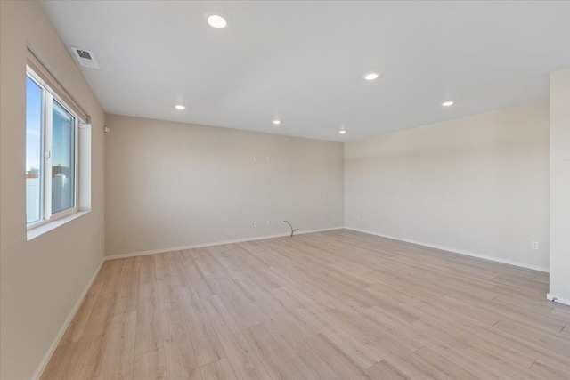 empty room with light wood-type flooring, visible vents, baseboards, and recessed lighting