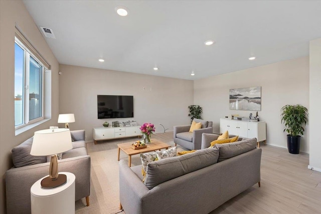 living area with light wood-type flooring, visible vents, baseboards, and recessed lighting