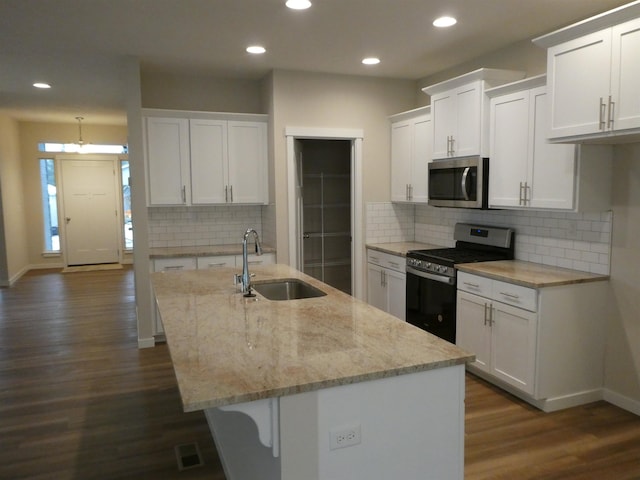 kitchen featuring stainless steel appliances, white cabinetry, a sink, and dark wood-type flooring