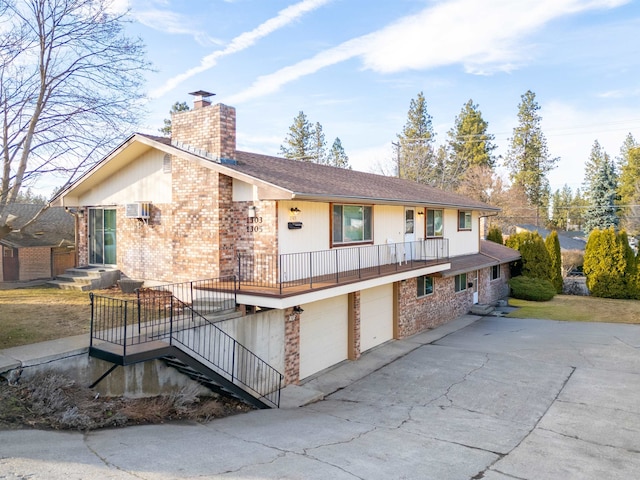 view of front facade with driveway, a garage, a chimney, a wall mounted AC, and brick siding