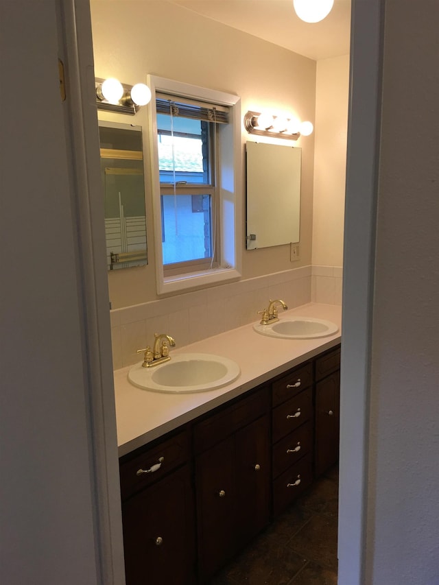 bathroom featuring double vanity, decorative backsplash, and a sink