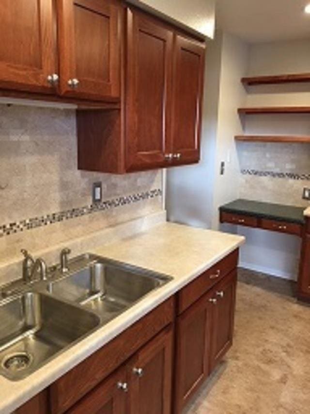 kitchen featuring light countertops, a sink, and backsplash