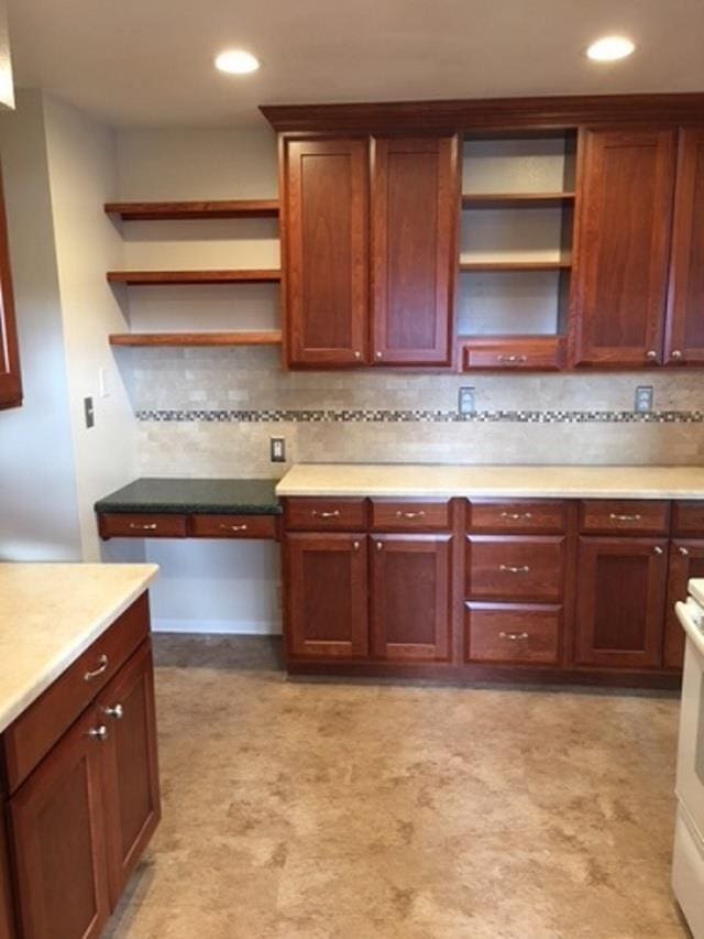 kitchen with open shelves, backsplash, and light countertops