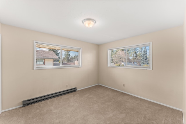 carpeted empty room featuring plenty of natural light, a baseboard heating unit, and baseboards