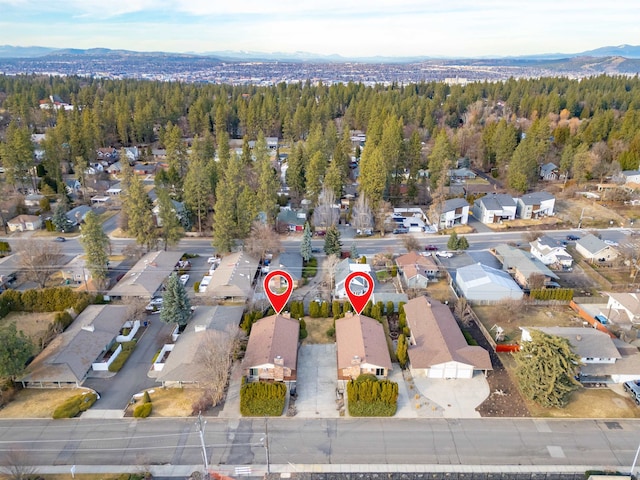 birds eye view of property with a residential view, a wooded view, and a mountain view