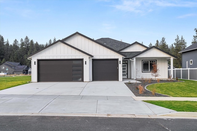 modern inspired farmhouse with an attached garage, a shingled roof, driveway, a front lawn, and board and batten siding