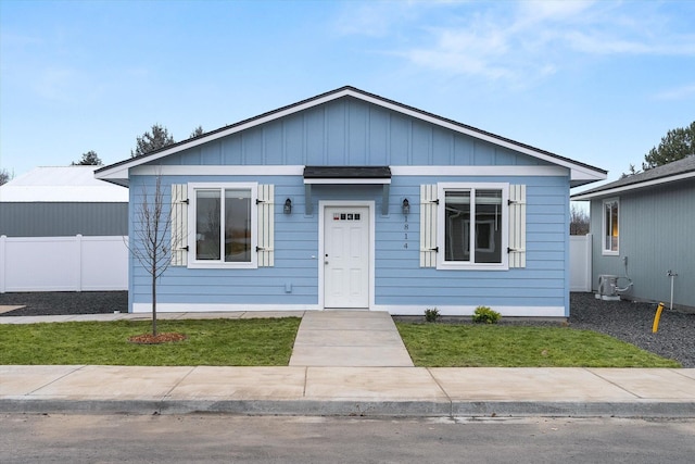 bungalow-style home featuring fence and a front lawn