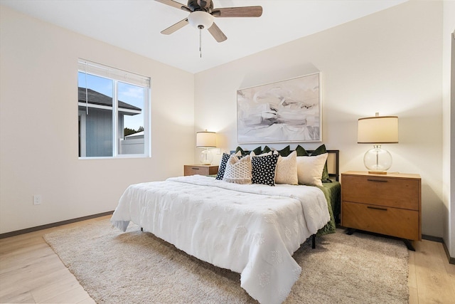 bedroom with light wood-type flooring, baseboards, and a ceiling fan