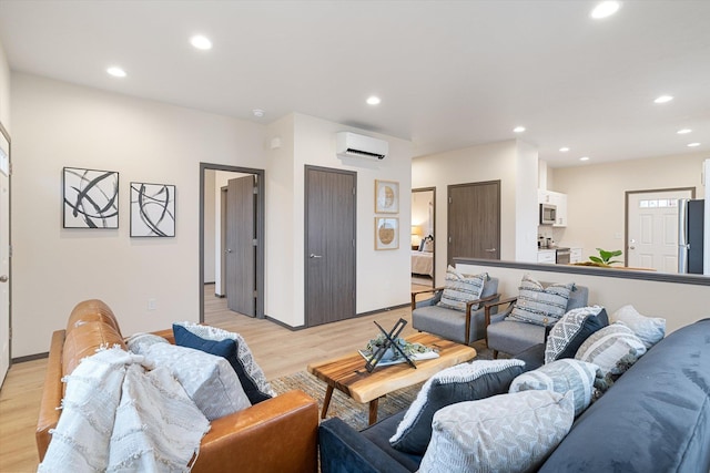 living area with baseboards, light wood finished floors, a wall mounted AC, and recessed lighting