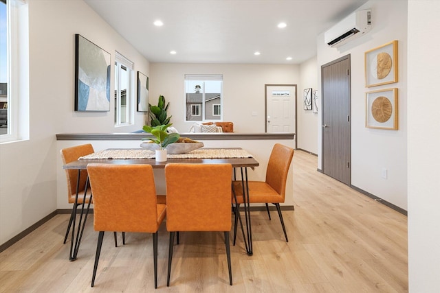 dining space with light wood-style floors, recessed lighting, a wall mounted air conditioner, and baseboards