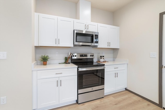 kitchen featuring stainless steel appliances, light countertops, white cabinets, and light wood finished floors