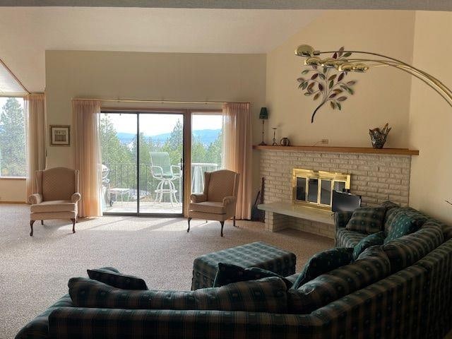 living room with carpet floors and a brick fireplace