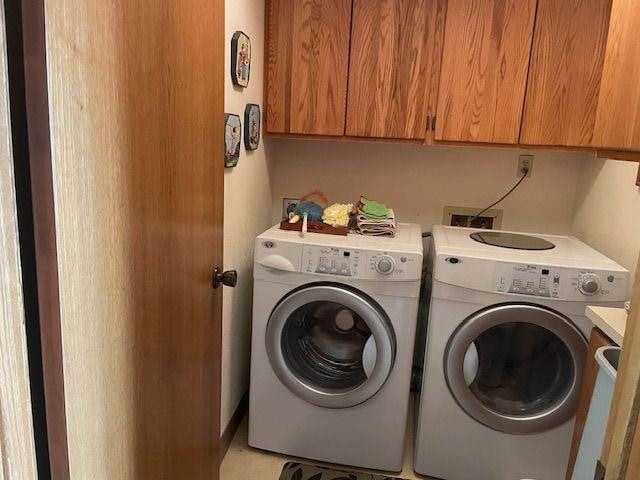 laundry room with washing machine and dryer and cabinet space