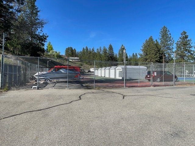 view of vehicle parking with fence