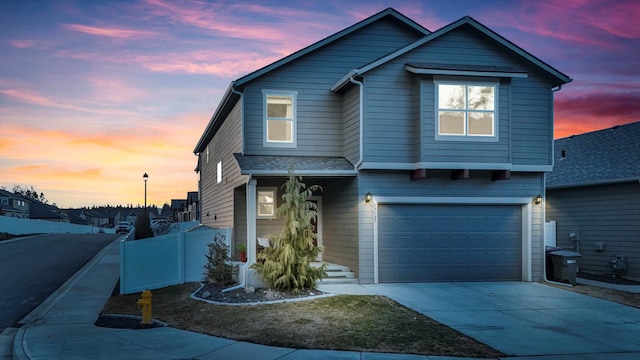 traditional-style home featuring concrete driveway, roof with shingles, fence, and an attached garage