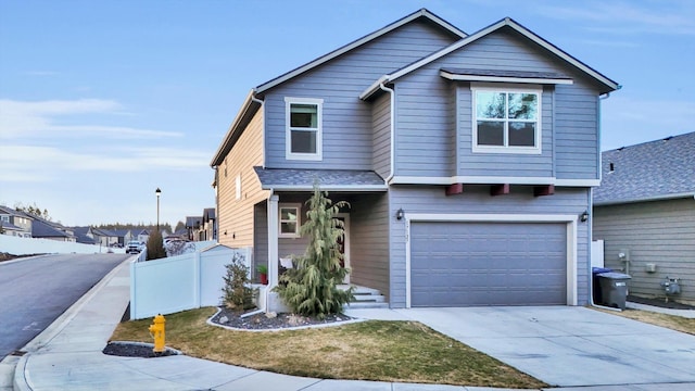 view of front of home with driveway, a garage, fence, and roof with shingles