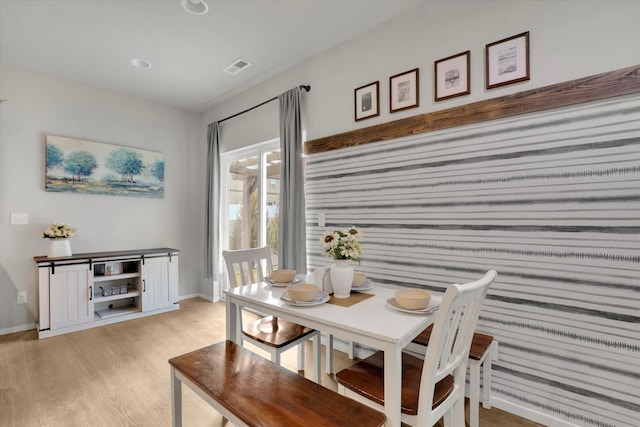 dining area with light wood finished floors, visible vents, and baseboards