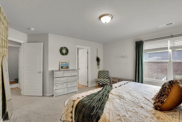 bedroom featuring a textured ceiling, carpet flooring, and visible vents