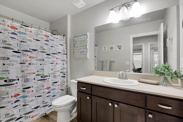 full bathroom featuring visible vents, vanity, toilet, and wood finished floors