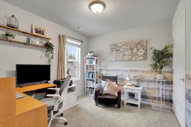 carpeted office space with a textured ceiling, a wainscoted wall, and visible vents