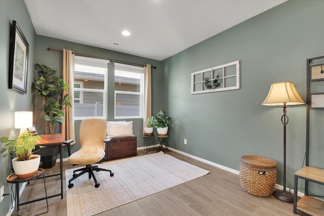 office space featuring wood finished floors, visible vents, and baseboards