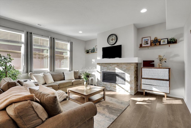 living room with a fireplace, recessed lighting, visible vents, wood finished floors, and baseboards