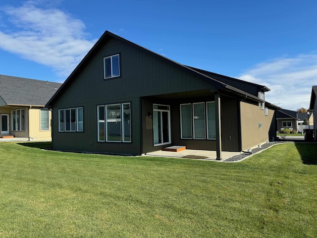 rear view of house with a patio and a lawn